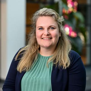 a woman with blonde hair and a green blouse is smiling